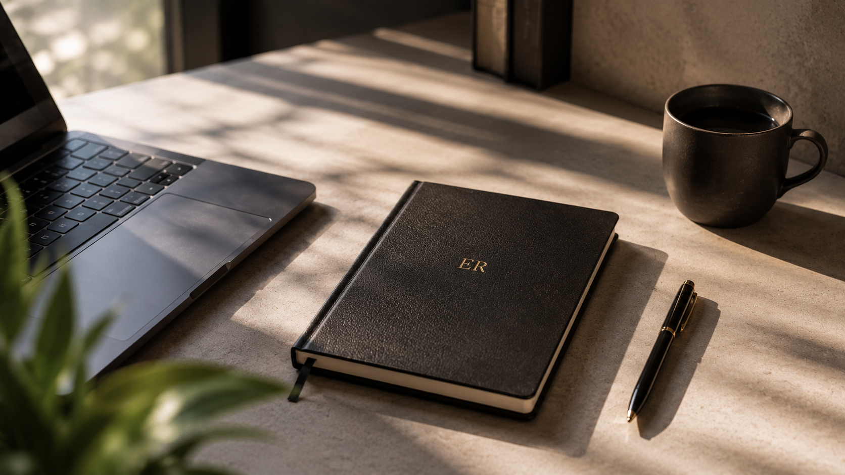 Carnet personnalisé aux initiales d'Etienne Rohr, sur un bureau baigné de lumière